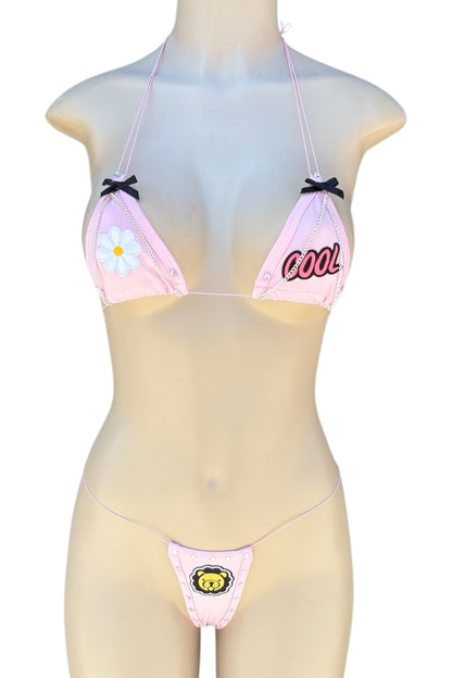 Mannequin wearing a pink bikini with floral and text design on a white background