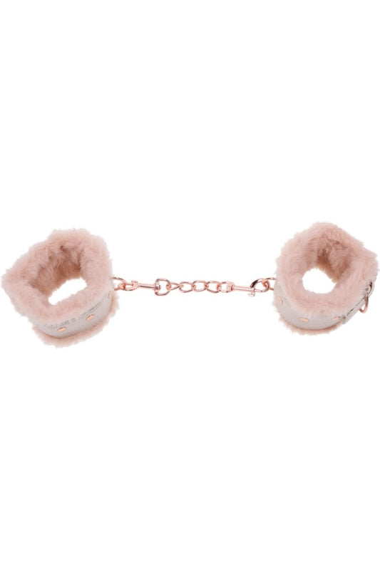 Pink fluffy handcuffs on a white background