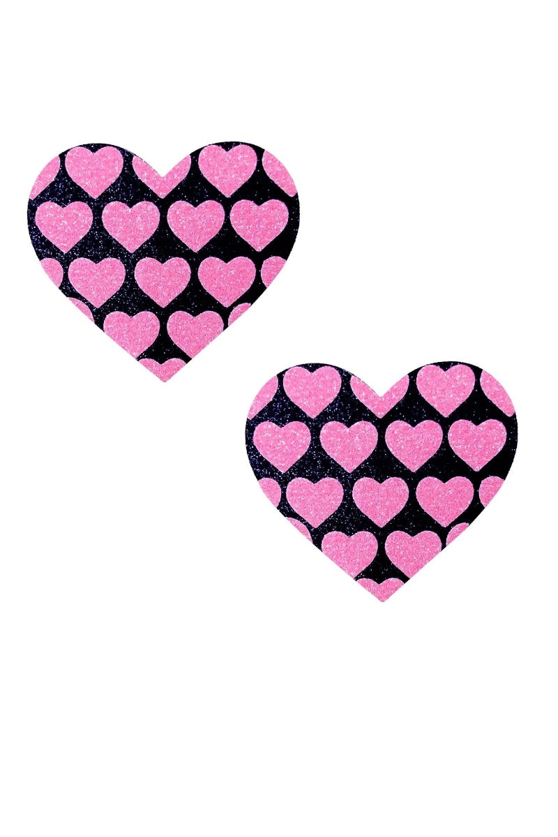 Two heart-shaped pasties with pink hearts on a black background.