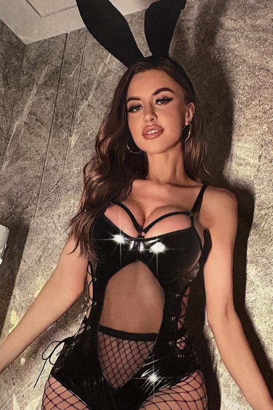 Person wearing a black bunny costume with fishnet stockings indoors.