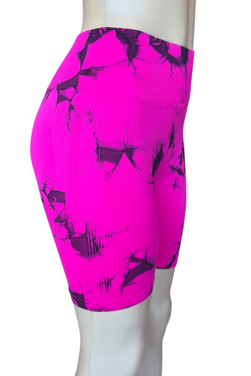 Bright pink athletic shorts with black abstract patterns on a mannequin against a white background