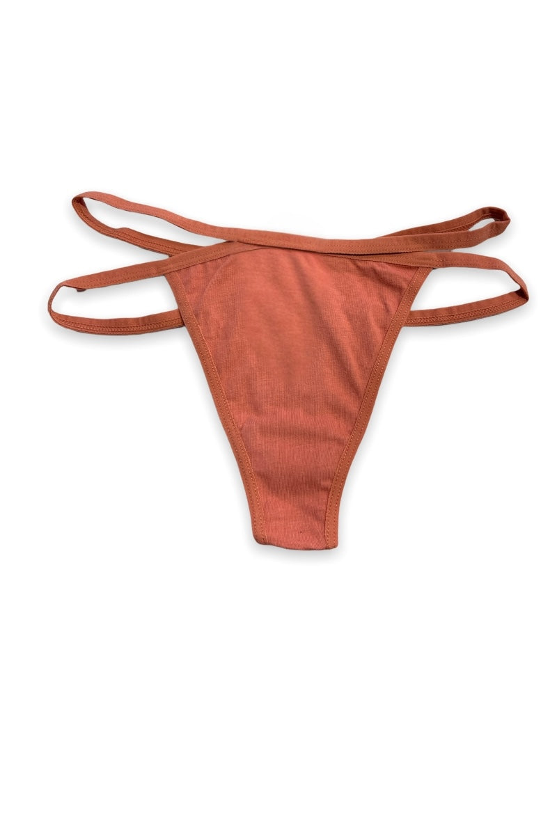 Rust thong with thin straps on a white background