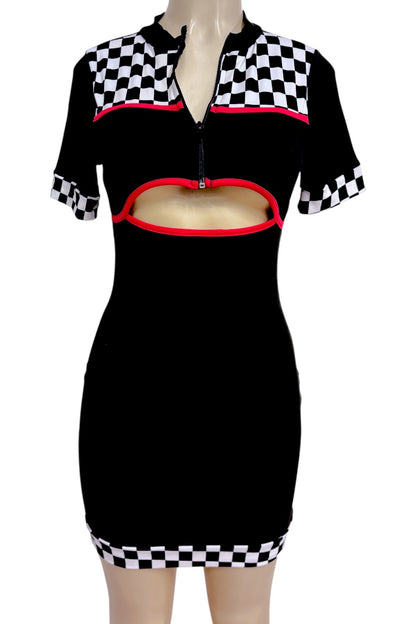 A black short-sleeve mini dress with a half-zip neckline, a horizontal cutout across the midsection, and checkered black-and-white panels at the shoulders and sleeve cuffs, accented with red piping.