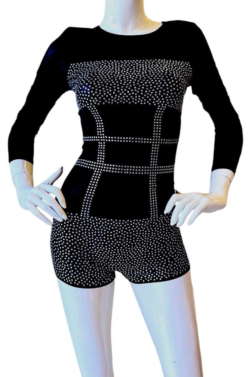 A black long-sleeve romper, displayed on a white mannequin. The bodysuit features a solid black base with silver rhinestone or glitter grid patterns across the chest, waist, and on the shorts.