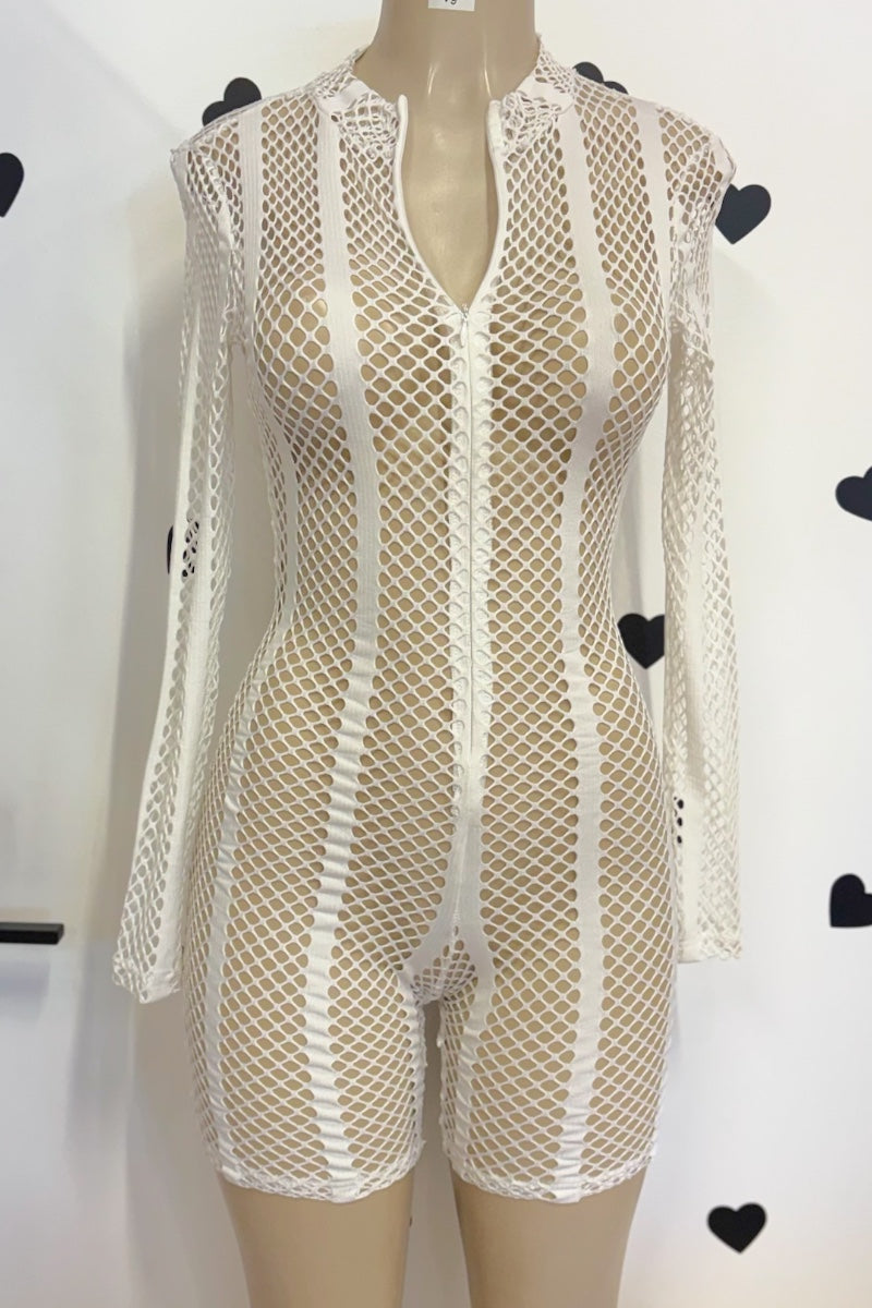A white fishnet romper with long sleeves and a front zipper, displayed on a beige mannequin torso against a white wall with black heart decorations.