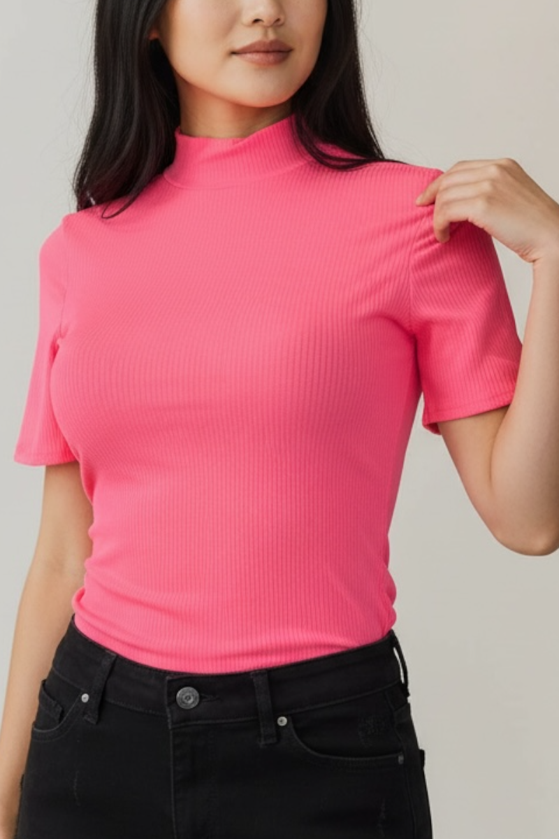 Person wearing a bright pink ribbed top against a neutral background