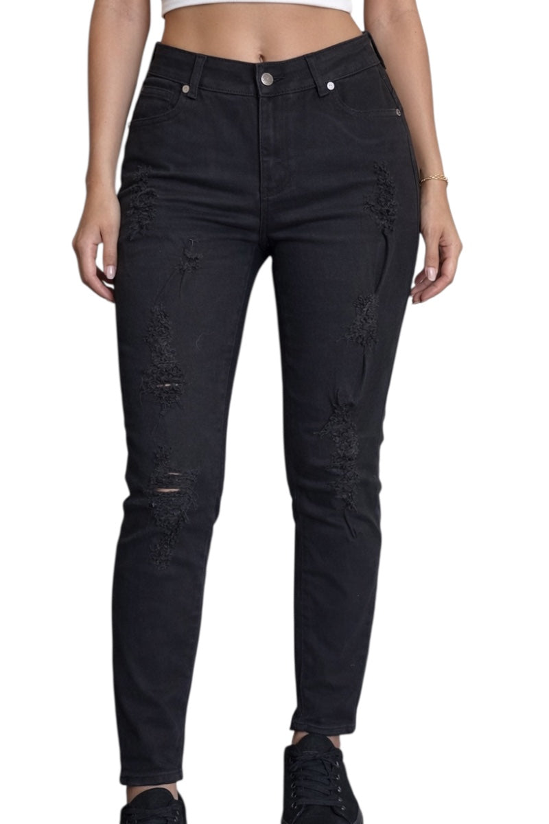 Black distressed jeans worn by a person on a white background