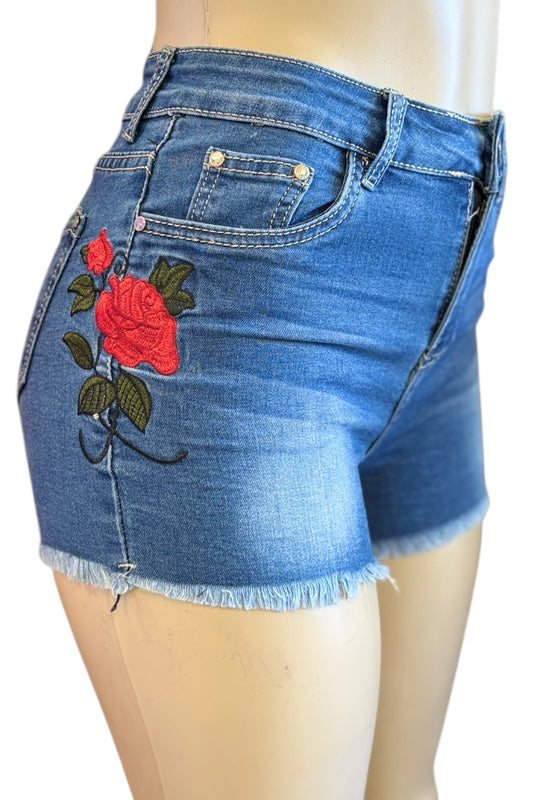 Blue denim shorts with red rose embroidery on a mannequin.
