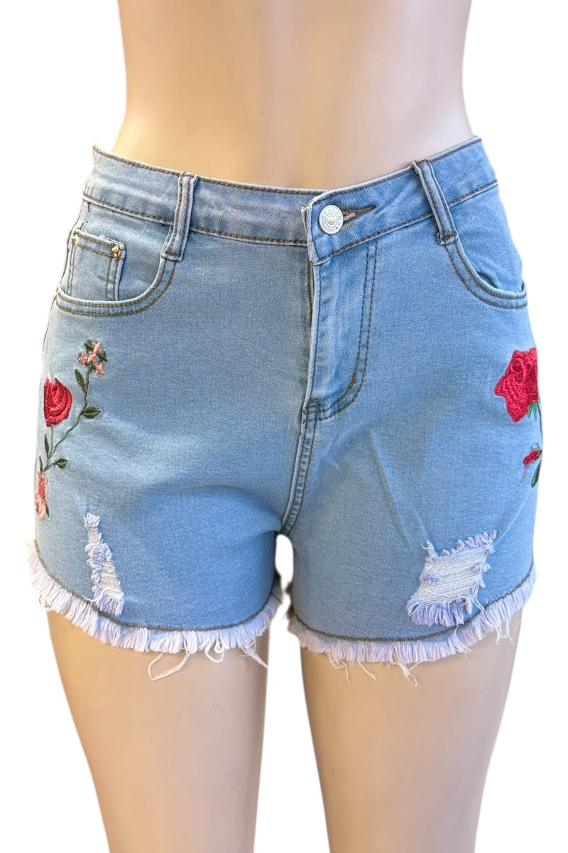 Blue denim shorts with floral embroidery on a white background