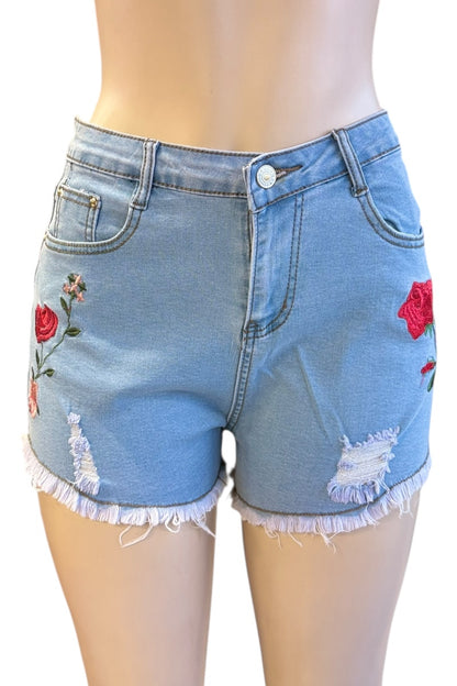 Blue denim shorts with floral embroidery on a white background
