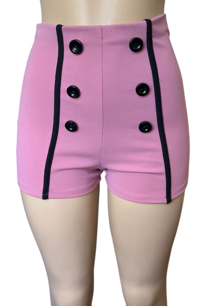 Pink shorts with black buttons and trim on a mannequin.