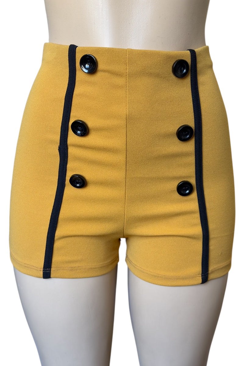 Mustard shorts with black buttons on a mannequin against a white background