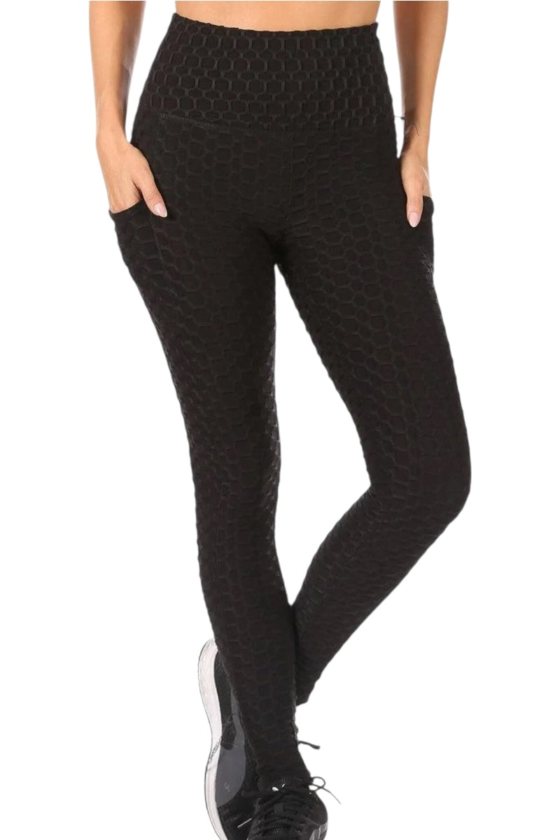 Black patterned leggings worn by a person on a white background