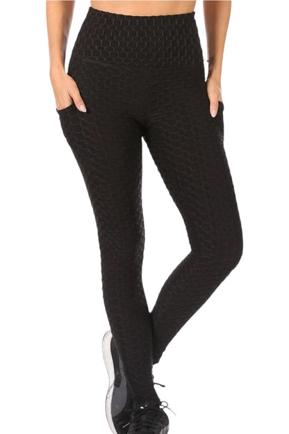 Black patterned leggings worn by a person on a white background