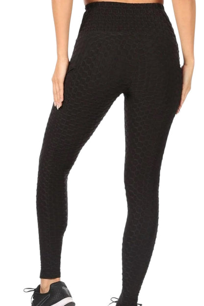 Black patterned leggings worn by a person on a white background