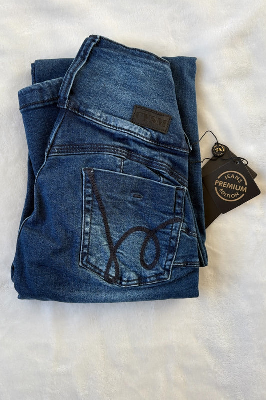 Folded blue jeans with a brand tag on a white background