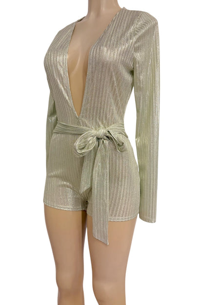 A metallic long-sleeve romper with a deep plunging V-neckline, vertical pleated texture, and a matching waist tie, displayed on a mannequin against a white background.