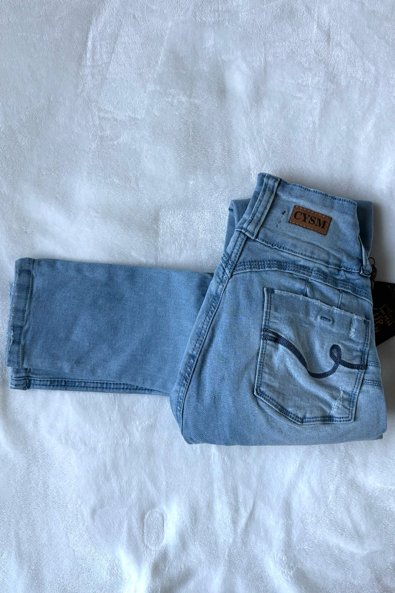 Folded blue jeans with a brand label on a white background