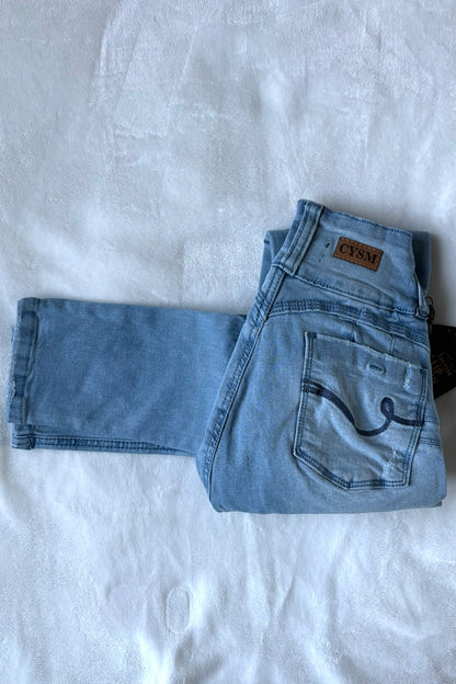 Folded blue jeans with a brand label on a white background