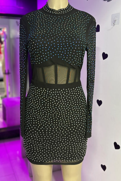 Black dress with rhinestones on a mannequin against a purple and white background.