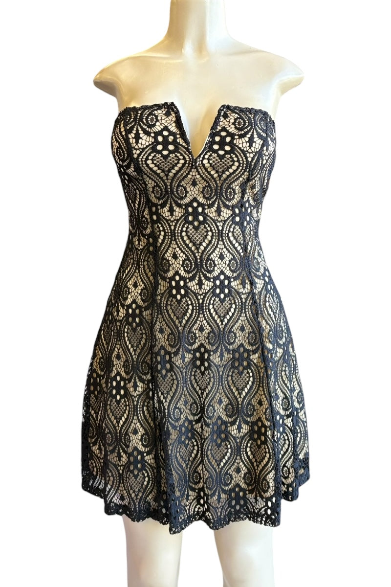 Black lace dress on a mannequin against a white background