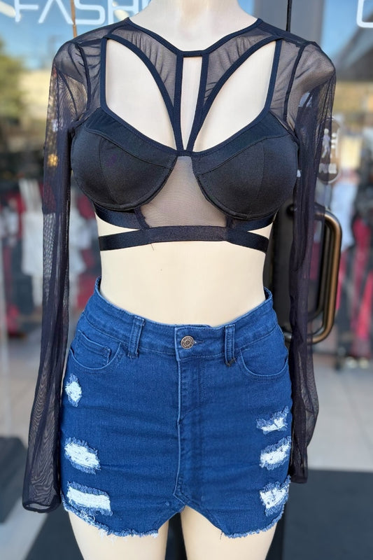 Mannequin wearing a black sheer top and blue denim skirt with white distressing.