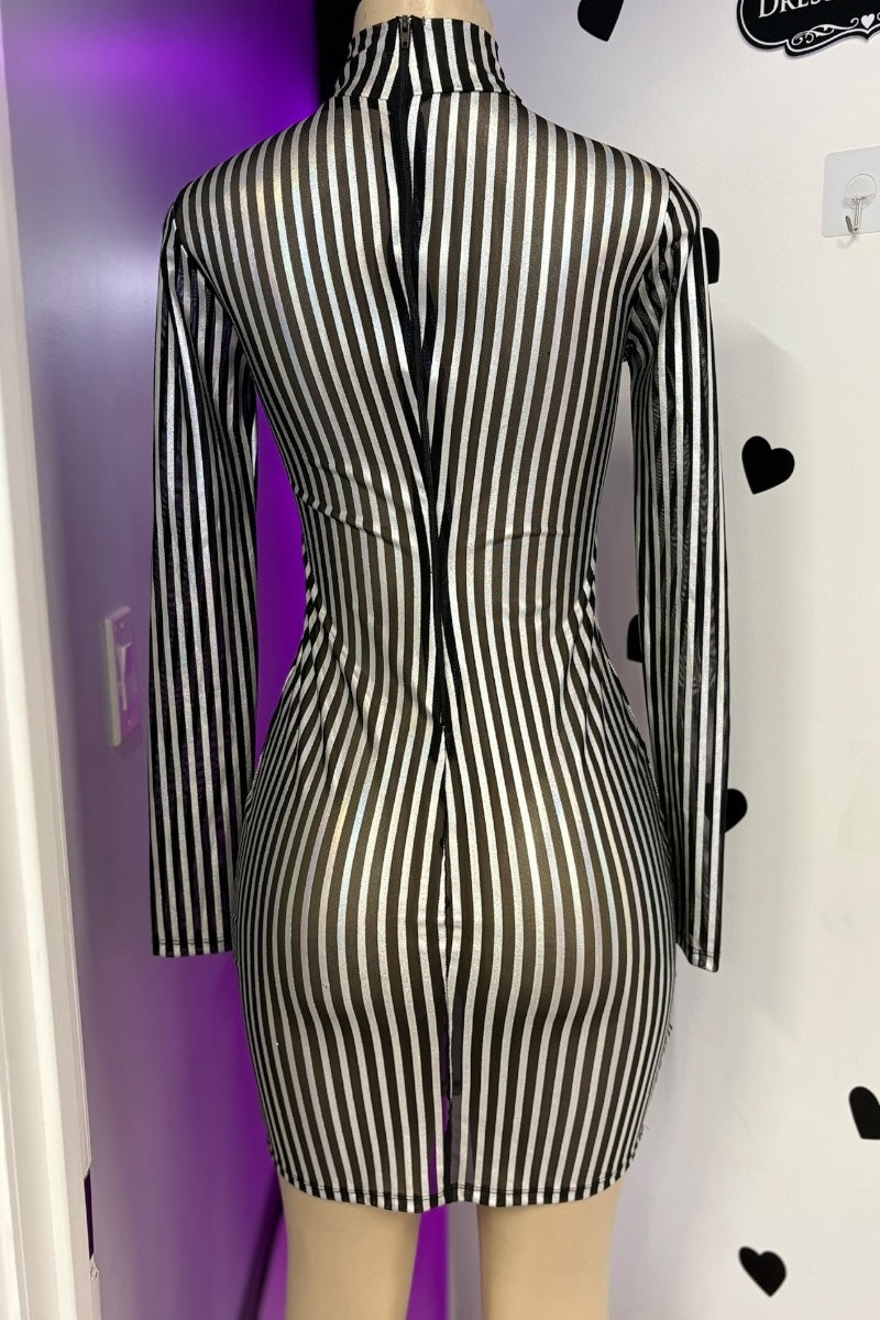 Black and silver striped dress on a mannequin against a purple and white wall.