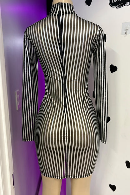 Black and silver striped dress on a mannequin against a purple and white wall.