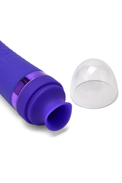 A close-up of a purple personal massager with a transparent dome-shaped cover placed beside it on a clean white background.