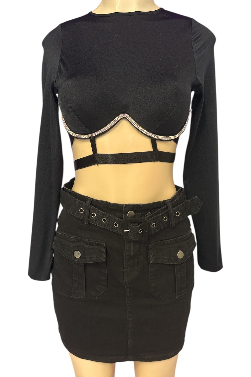 Black long-sleeve top with cut-out design and black skirt on a mannequin against a white background