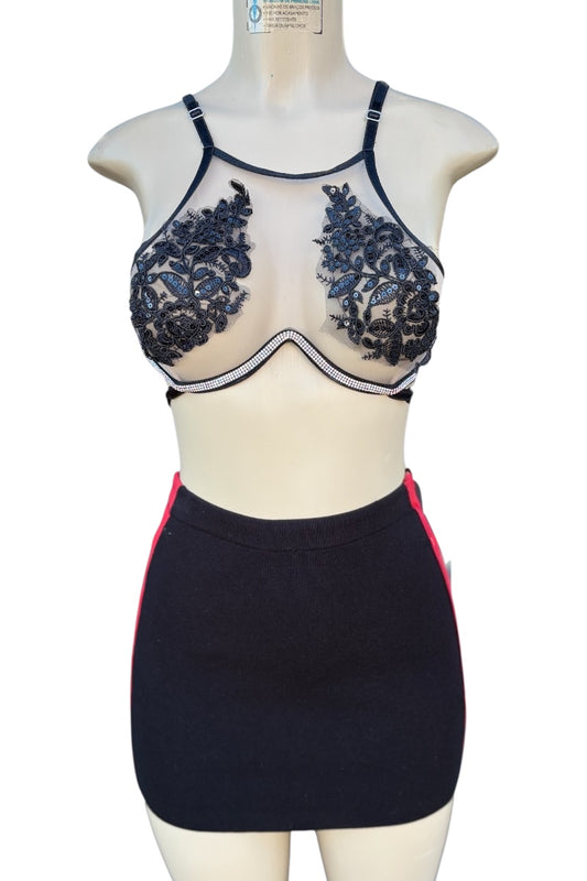 Mannequin wearing a black lace bra top and skirt set on a white background