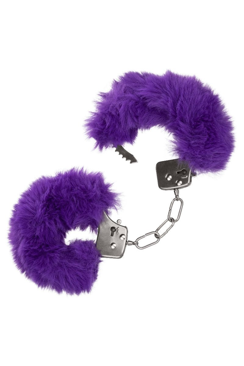 Purple furry handcuffs on a white background