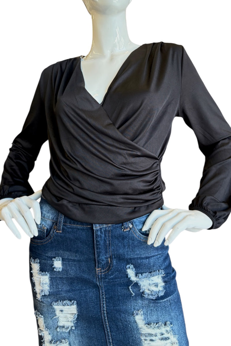 A black long-sleeve wrap-style top displayed on a mannequin torso, paired with a distressed blue skirt against a plain white background.