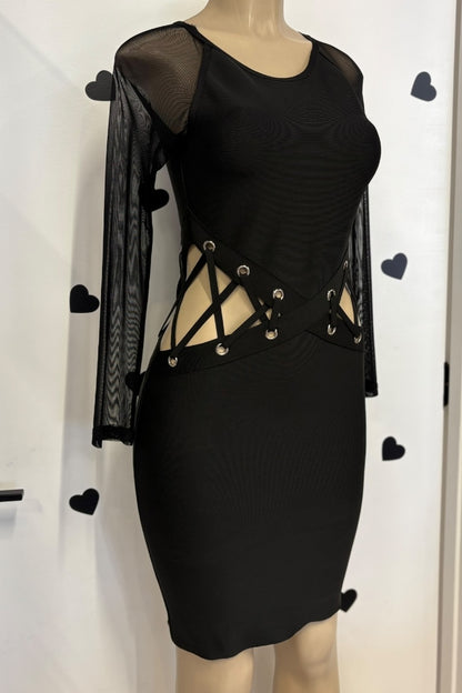 Black dress with sheer sleeves and lace-up details on a mannequin against a white background.