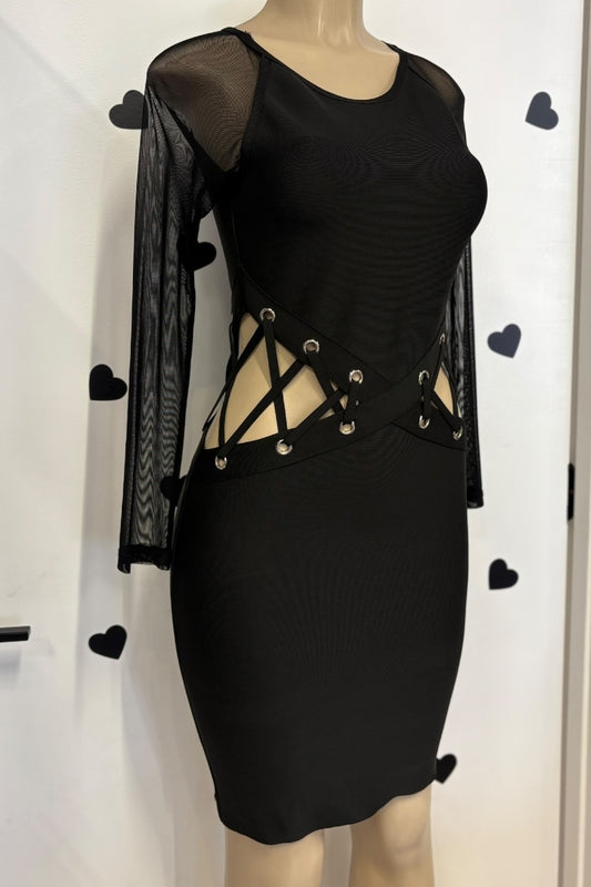 Black dress with sheer sleeves and lace-up details on a mannequin against a white background.