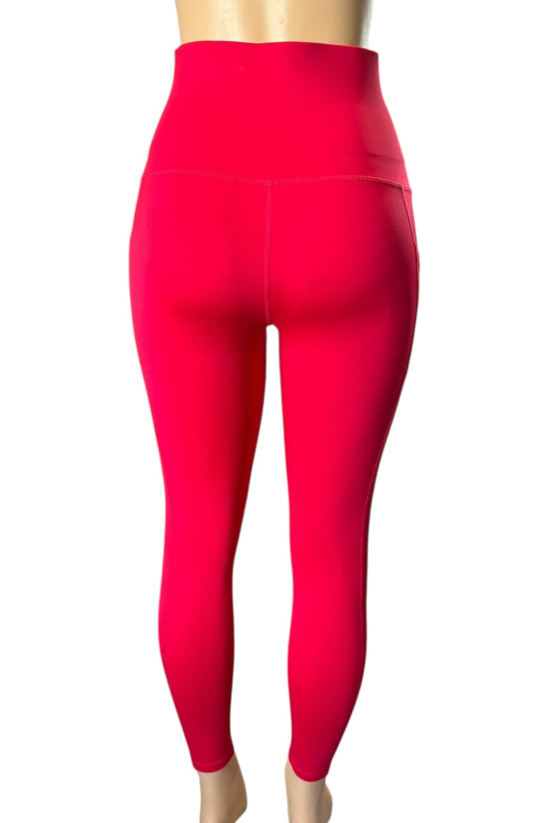 Red leggings on a mannequin against a white background