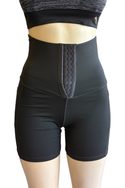 Black high-waisted compression shorts with a textured central panel, shown on a mannequin torso with a matching black sports bra cropped at the chest.