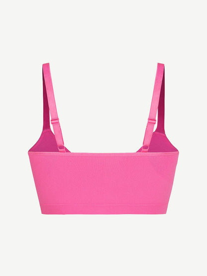 Fuchsia bralette with thin straps on a light gray background