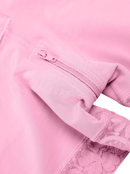 Close-up of a pink garment with lace detailing on a white background