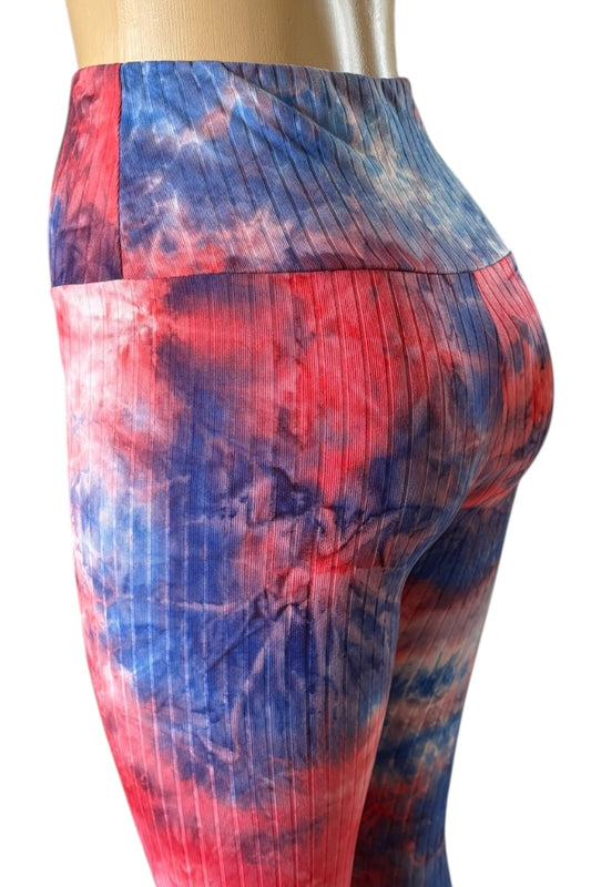 Colorful tie-dye leggings with a pattern of red, and blue on a white background.