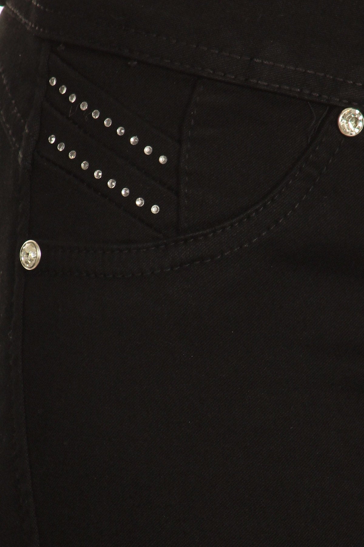 Close-up of black pants with decorative studs on a dark background