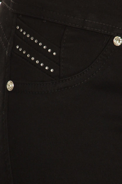 Close-up of black pants with decorative studs on a dark background