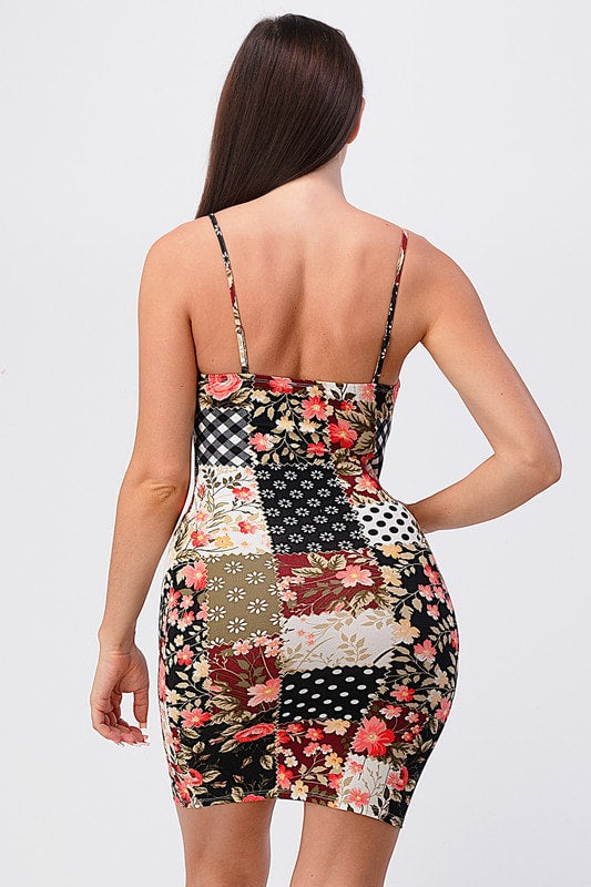 Woman wearing a patchwork dress with floral and geometric patterns on a white background