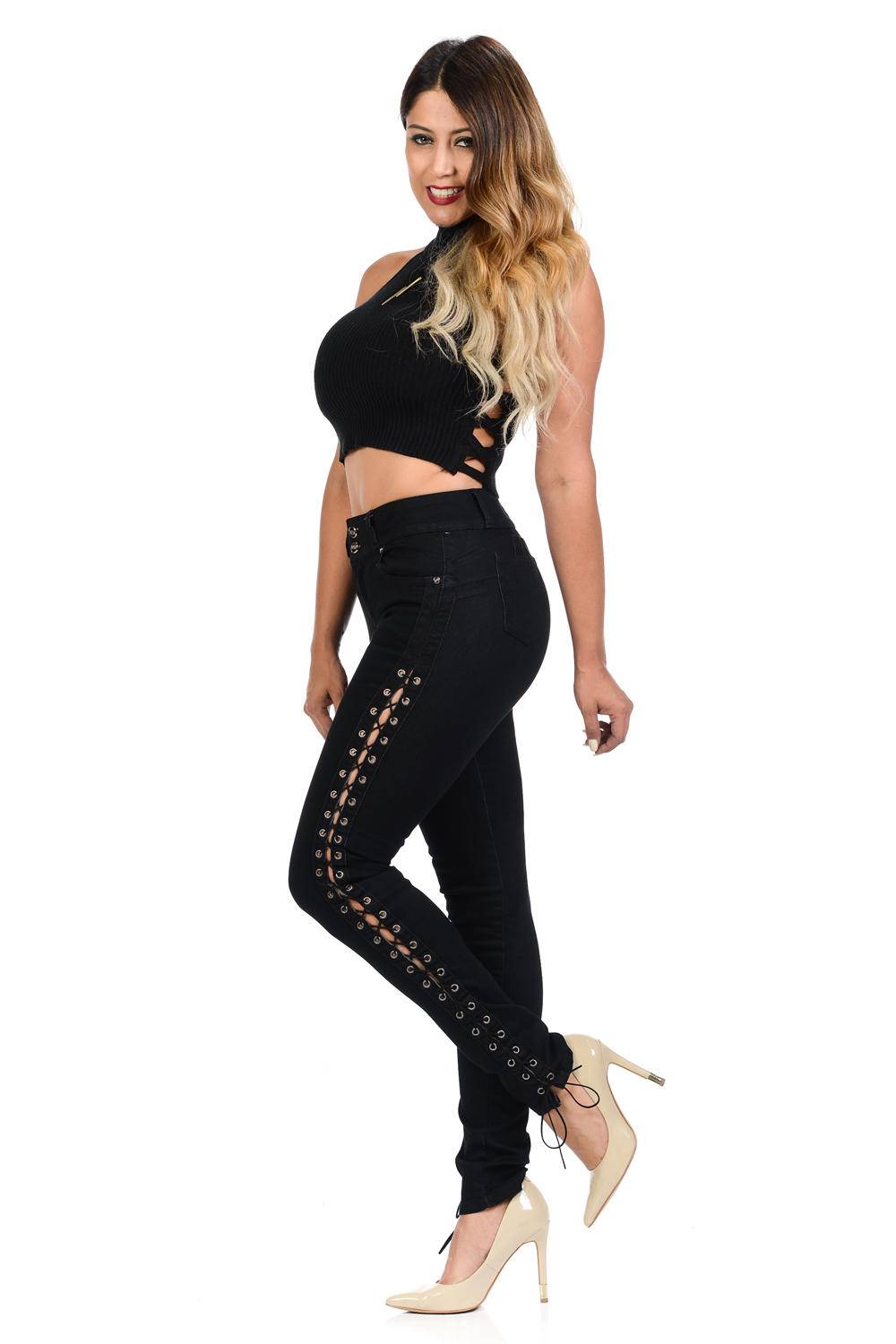 Woman wearing a black outfit with lace-up details on a white background