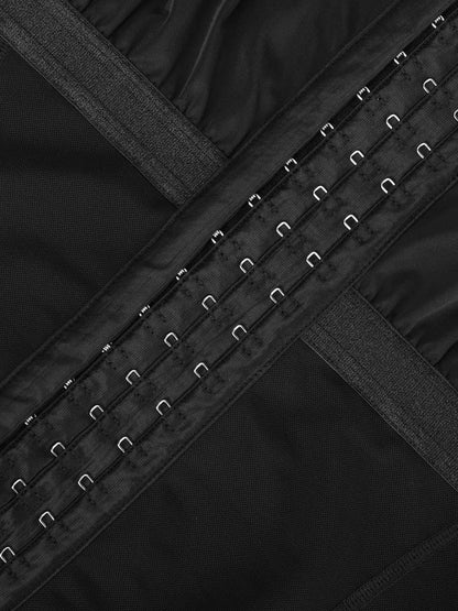 Close-up of a black garment with metal buttons and straps.