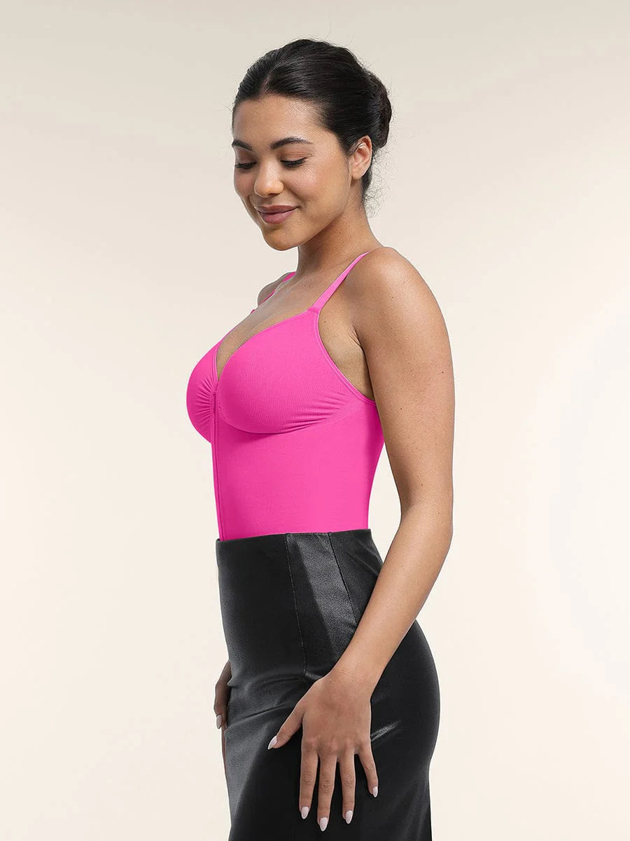 Woman wearing a bright pink top and black skirt on a plain background
