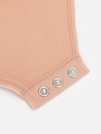 Close-up of a beige-colored fabric with silver buttons on a white background