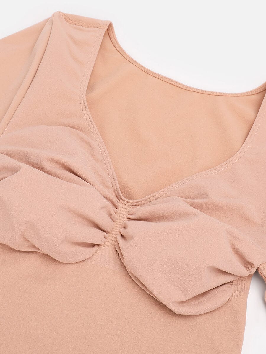 Close-up of a beige-colored top with a scrunched detail on a white background