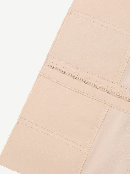 Close-up of beige shorts with corset detail on a white background