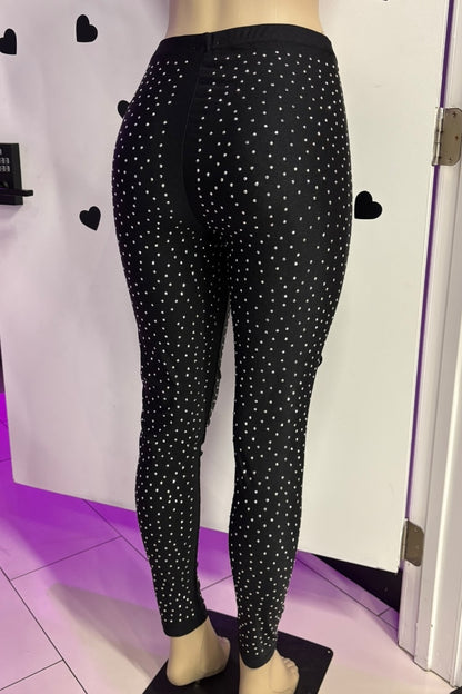 Black leggings with rhinestones on a mannequin against a white background.